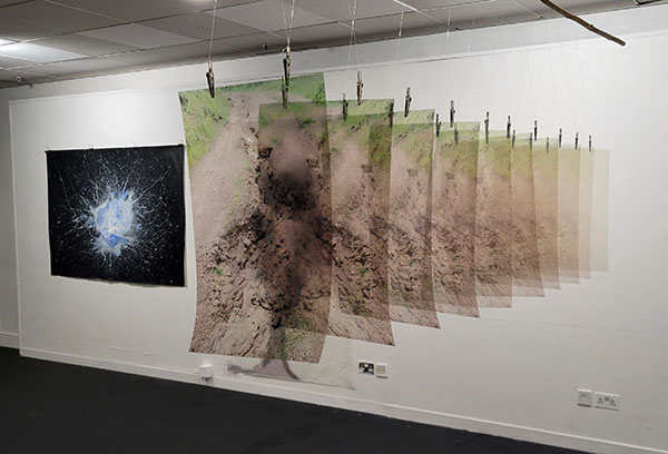 Maria Markham, Erosion, 2024. 10 prints, crystal clear film, branch, alligator pins, fishing line, dimensions variable